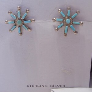 May include: A pair of sterling silver earrings with turquoise stones in a starburst design.