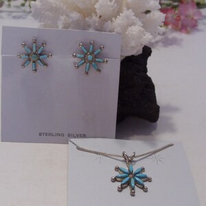 May include: A set of sterling silver earrings and a necklace featuring turquoise flower designs. The earrings and pendant are both in the shape of a starburst with turquoise stones set in the center and around the edges.