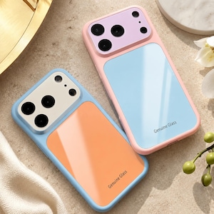 May include: Two rectangular phone cases with a glossy finish. One case is light blue with an orange back panel, the other is light pink with a light blue back panel. Both feature a camera cutout area and the text Genuine Glass printed on the back.