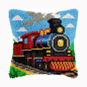 Peut inclure: Un coussin carré en crochet à loquet représentant une locomotive à vapeur colorée. Le train est noir, rouge et bleu avec des accents jaunes, sur un ciel bleu vif avec des nuages blancs et des éléments de paysage verts en bas.