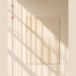 May include: A rectangular beige textile wall hanging composed of several stitched fabric panels with a visible grid pattern. The piece features a subtle textured surface and is adorned with Korean characters and a small red stamp in the upper left corner.