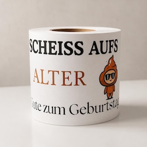 Puede incluir: Un rollo de papel higi&eacute;nico blanco con el texto negro "SCHEISS AUFS", el texto marr&oacute;n "ALTER" y el texto negro "Gute zum Geburtstag". En el lateral hay impreso un personaje de dibujos animados con forma de emoji de caca marr&oacute;n con gafas.