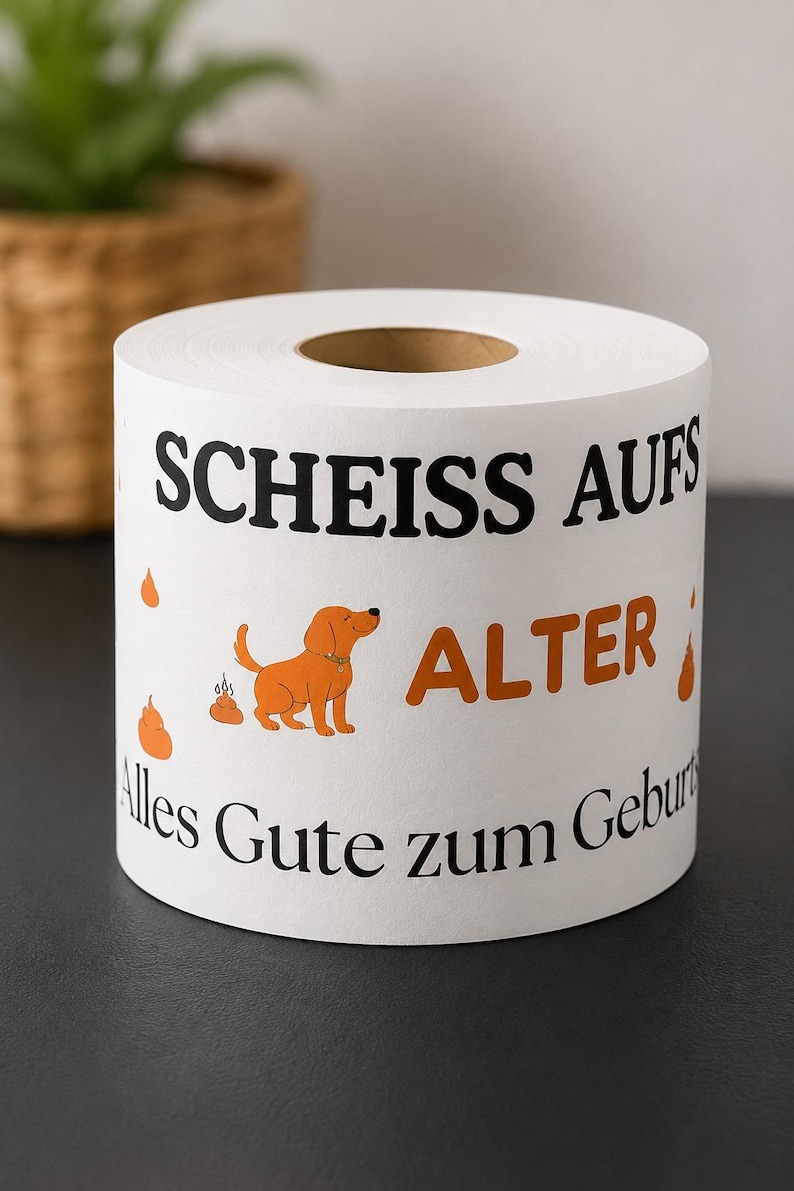 Puede incluir: Un rollo de papel higi&eacute;nico blanco con texto en negro y naranja que dice "SCHEISS AUFS ALTER" y "Alles Gute zum Geburtstag". El dise&ntilde;o incluye una peque&ntilde;a ilustraci&oacute;n de un perro naranja y varios iconos de excrementos naranjas impresos.