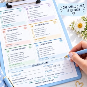 May include: A light blue clipboard holding a daily task checklist with six numbered sections including Wake & Reset, Body & Basics, Food & Energy, See Today Clearly, Take What You Need, and Choose & Begin. The text One Small Start Is Enough is visible.