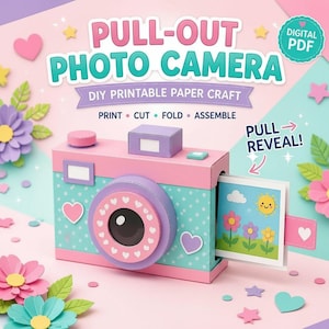May include: A DIY printable paper craft kit for a pull-out photo camera. The camera is light blue with white polka dots, pink accents, and a purple lens. A pull-out tab reveals a cartoon sun and flower illustration. Text reads PULL-OUT PHOTO CAMERA.
