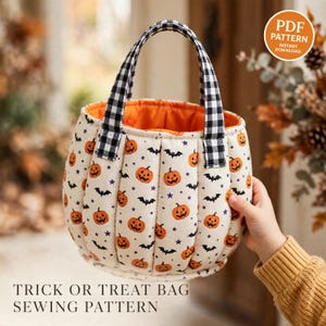 Puede incluir: Una bolsa de tela acolchada para dulces con un patrón repetitivo de calabazas naranjas, murciélagos negros y pequeñas estrellas moradas sobre un fondo crema. La bolsa tiene asas de cuadros vichy en blanco y negro y un forro interior naranja brillante.