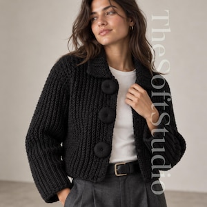 May include: A black chunky knit cardigan featuring a collared neckline, long sleeves, and three large, round, fabric-covered buttons down the front. The text TheSoftStudio is visible on the right side of the image.
