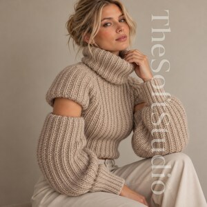 May include: A beige ribbed knit sweater featuring a high turtleneck, long sleeves with cut-out shoulders, and voluminous cuffs. The garment has a textured vertical pattern throughout and is paired with light-colored trousers.
