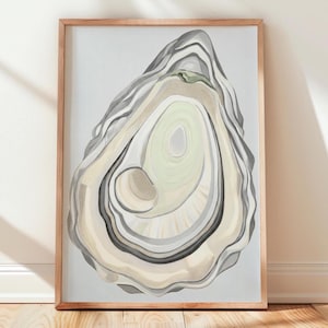 May include: A framed wall art print featuring a detailed illustration of an open oyster shell. The shell displays layered textures in shades of cream, light grey, and soft green, set against a pale grey background within a light wood frame.