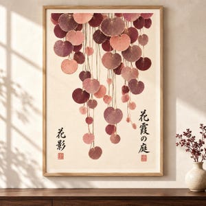 May include: A framed wall art print featuring a vertical arrangement of hanging circular leaves in shades of pink, mauve, and deep burgundy. The cream-colored background includes black Japanese calligraphy text and two small red square stamps.