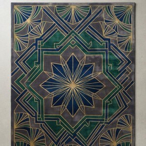 Puede incluir: Una alfombra rectangular con un patrón geométrico y un diseño central de estrella. La alfombra presenta una paleta de colores azul profundo, verde bosque y gris carbón, acentuada por finas líneas doradas que forman abanicos.