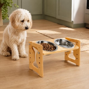May include: A light-colored wooden elevated pet feeder stand featuring two circular stainless steel bowls. One bowl is filled with brown dry kibble, while the other is empty. The stand has adjustable side panels with visible metal hardware.