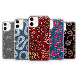 Puede incluir: Cinco fundas para smartphone dispuestas en fila, cada una con un patrón de serpiente distinto. Los diseños incluyen serpientes blancas, doradas, rojas y multicolores sobre fondos gris oscuro, azul, rojo intenso y negro, con aberturas para cámara dual.