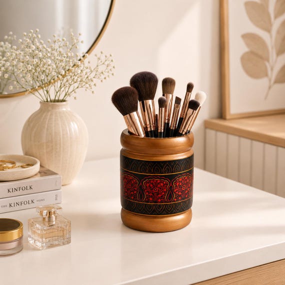 A Sheesham wood pen holder hand-decorated in traditional Pakistani lacquer art — bold geometric color patterns that look like a museum craft piece sitting on your desk.