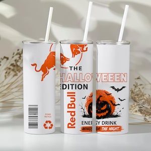 Könnte beinhalten: Drei weiße zylindrische Becher mit Strohhalmen, verziert mit orangefarbenen Red Bull Logos, dem Text THE HALLOWEEN EDITION und einer Grafik eines Kürbiskopfes vor einem Vollmond mit Fledermäusen. Jeder Becher zeigt einen Strichcode.