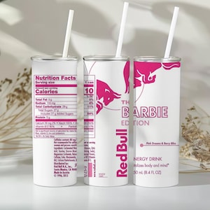 May include: Three cylindrical white tumblers with pink accents and white straws. The design mimics a Red Bull energy drink can, featuring nutrition facts, the Red Bull logo, and the text The Barbie Edition, Pink Dreams & Berry Bliss, 8.4 FL OZ.