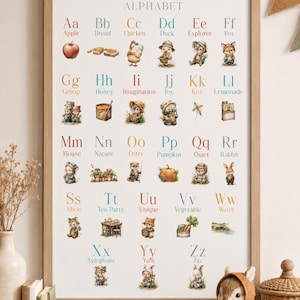 Könnte beinhalten: Ein gerahmtes pädagogisches Wandposter mit dem Titel The Woodlandies Alphabet, das die Buchstaben A bis Z zusammen mit entsprechenden Wörtern und Illustrationen von anthropomorphen Waldtieren und Naturmotiven in sanften Farben zeigt.