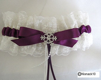 May include: White lace garter with a purple satin bow and a rhinestone snowflake embellishment.