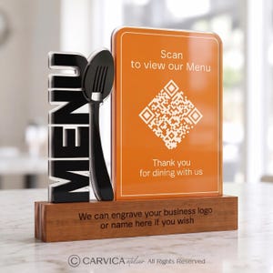 May include: A rectangular orange acrylic sign with a white QR code and the text Scan to view our Menu and Thank you for dining with us. Next to it is a black 3D word MENU and a spoon icon on a rectangular wooden base with engraved text.