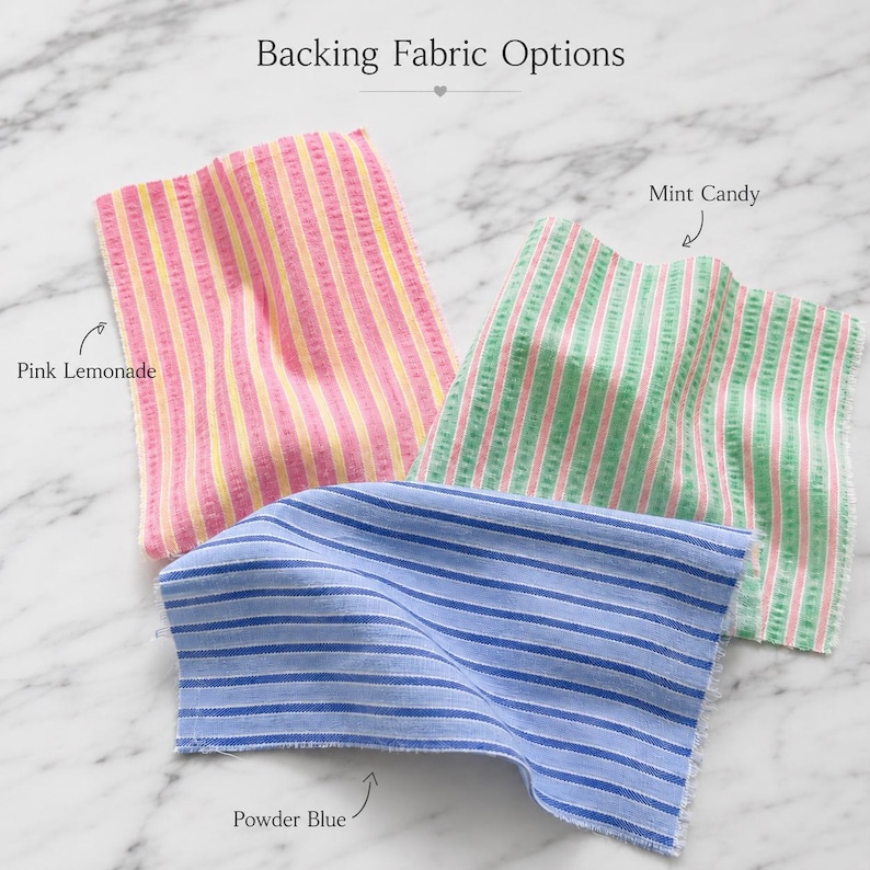 Może przedstawiać: Trzy pr&oacute;bki tkanin z nagł&oacute;wkiem Backing Fabric Options. Jedna pr&oacute;bka ma r&oacute;żowo-ż&oacute;łte pionowe paski z etykietą Pink Lemonade. Druga ma zielono-r&oacute;żowe pionowe paski z etykietą Mint Candy. Trzecia ma niebiesko-białe poziome paski z etykietą Powder Blue.