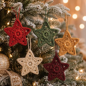 May include: Five star-shaped crochet ornaments in red, dark green, mustard yellow, cream, and burgundy. Each star features a central circular pattern with intricate openwork stitching and a matching yarn loop for hanging on a tree branch.