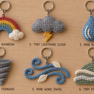 Peut inclure: Six porte-clés en crochet sur le thème de la météo : un arc-en-ciel avec des nuages, un nuage gris avec un éclair jaune, une goutte de pluie bleue, une tornade grise, des tourbillons de vent bleus avec des feuilles blanches et une colline verte.