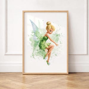 May include: A framed art print featuring a watercolor illustration of a blonde fairy with translucent wings, wearing a green dress. The fairy is depicted in a dynamic pose against a backdrop of green paint splatters and light green watercolor washes.