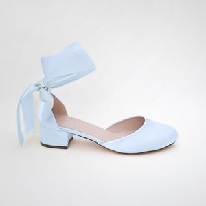 May include: Light blue satin heeled shoes with a matching satin ribbon tied around the ankle.