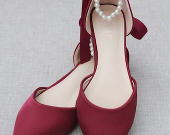 May include: Burgundy satin pointed toe flats with a pearl ankle strap and a matching satin ribbon tie.