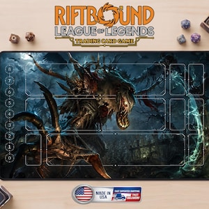 May include: A rectangular playmat for the Riftbound League of Legends trading card game, featuring a dark, monstrous creature illustration with sharp claws and glowing eyes, overlaid with white game board markings and a numbered life counter.