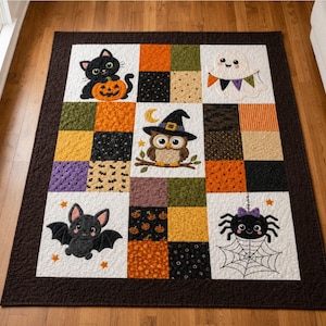 May include: A rectangular Halloween-themed quilt featuring a dark brown border and a grid of patchwork squares. The design includes appliqued motifs of a black cat with a pumpkin, a white ghost with bunting, an owl in a hat, a bat, and a spider.