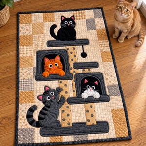 May include: A rectangular fabric wall hanging featuring a quilted patchwork background in shades of tan, beige, and gray. The design depicts a cat tree with four cats: a black cat on top, an orange cat, a black and white cat, and a gray tabby cat.