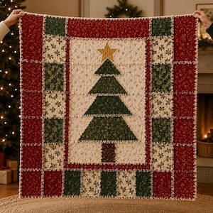 May include: A rectangular rag quilt featuring a central cream-colored panel with a green fabric Christmas tree and a gold star at the top. The quilt is bordered by alternating squares of red floral fabric and green holly-patterned fabric.