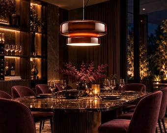 May include: A modern pendant light fixture featuring a tiered, glossy dark amber glass shade suspended by a thin cord, emitting a warm, downward-facing glow over a dining table set with glassware and a dark vase with red foliage.