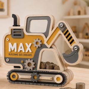 Può includere: Un salvadanaio in legno a forma di escavatore con una combinazione di colori giallo e grigio. Il lato è stampato con il nome MAX e il testo BUILDING BIG DREAMS. La struttura include dettagli a forma di ingranaggio e un pannello trasparente.
