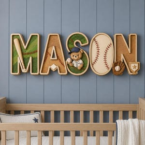 Op de afbeelding: Een houten wandbord met de naam MASON in grote blokletters. Elke letter is voorzien van decoraties in honkbalthema, waaronder een knuppel, een honkbal, een bruine teddybeer met een petje en een kleine trofee met een ster.