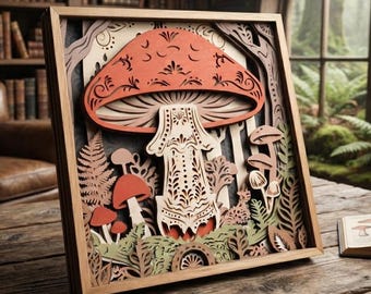 May include: A square wooden framed wall art piece featuring a multi-layered laser-cut design of a large central mushroom with intricate filigree patterns in shades of orange, cream, and brown, surrounded by smaller mushrooms and fern foliage.
