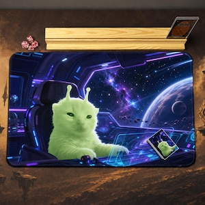 May include: A rectangular playmat featuring a neon green cat with antennae sitting in a spaceship cockpit. The background shows a view of space with a planet, stars, and a nebula. A small matching card is placed on the mat, and a wooden stand is above.