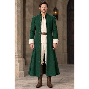 Puede incluir: Un abrigo largo de color verde oscuro con cuello alto y una fila completa de botones en la parte delantera. Debajo, una camisa color crema con escote acordonado, pantalones color crema, un cinturón de cuero marrón y botas de cuero marrón.
