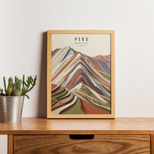 Puede incluir: Una lámina de arte mural vertical enmarcada que presenta una ilustración estilizada de la Montaña de Siete Colores en Perú. La obra muestra estratos geológicos superpuestos y multicolores en tonos rojo, verde, azul y crema, con el texto PERU.