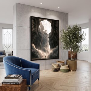 May include: A large rectangular framed wall art piece featuring a dark, dramatic architectural scene with a central winged figure emerging from clouds and stone pillars. The artwork is mounted on a light gray concrete wall above a blue velvet armchair.