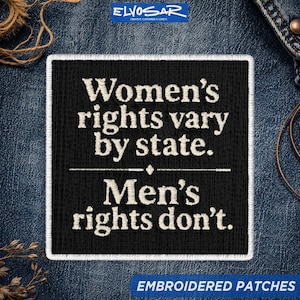May include: A square black embroidered patch with a white border. The text in white embroidery reads: Women's rights vary by state. Men's rights don't. A thin horizontal line with a small diamond shape in the center separates the two sentences.