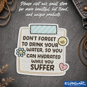 May include: A rectangular embroidered patch featuring a light-colored background with a light blue striped tape graphic at the top. The text reads: DON'T FORGET TO DRINK YOUR WATER, SO YOU CAN HYDRATED WHILE YOU SUFFER. Includes a small flower, smiley face, and heart.