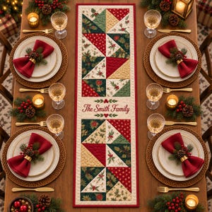 May include: A rectangular quilted table runner featuring a patchwork design of red, green, and cream fabric triangles with holly and poinsettia patterns. The centre displays the text The Smith Family in red script, bordered by a red fabric trim.
