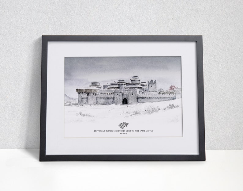 May include: A framed print of a watercolor painting depicting a grey stone castle in a snowy landscape. The castle has multiple towers and a large gate. The text below the image reads "Different roads sometimes lead to the same castle."