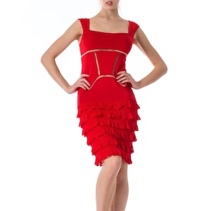 Puede incluir: Un vestido rojo sin mangas con falda de volantes y un panel transparente en la cintura.