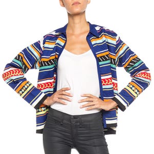 May include: A long-sleeved shirt with a colourful striped pattern. The shirt has a button-up collar and a relaxed fit. The stripes are in shades of blue, red, orange, yellow, green, and white.