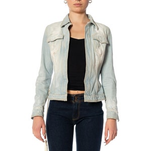 May include: A light blue denim jacket with a faded look. The jacket has a button-up front, long sleeves, and two pockets on the chest.