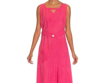 May include: A sleeveless maxi dress in a vibrant pink hue. The dress features a square neckline with a keyhole detail and a fitted bodice. A matching belt cinches the waist, and the skirt flows to the floor.