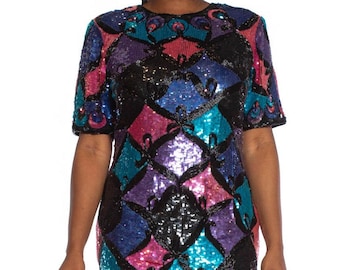 Puede incluir: Un vestido corto de lentejuelas con un patrón geométrico en tonos de rosa, morado, azul y negro.